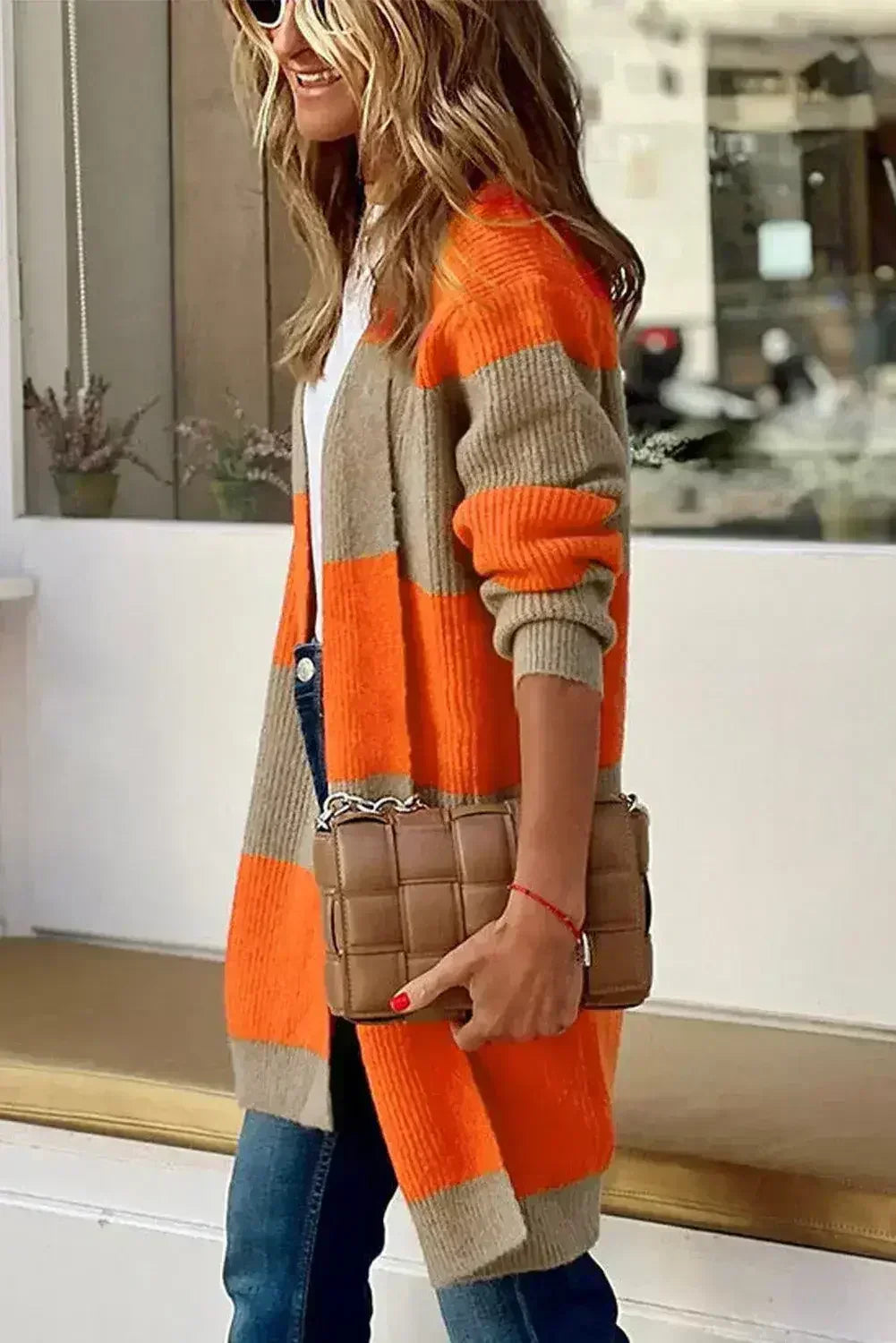 Beige and orange colorblock ribbed knit cardigan worn with long sleeves and open front
