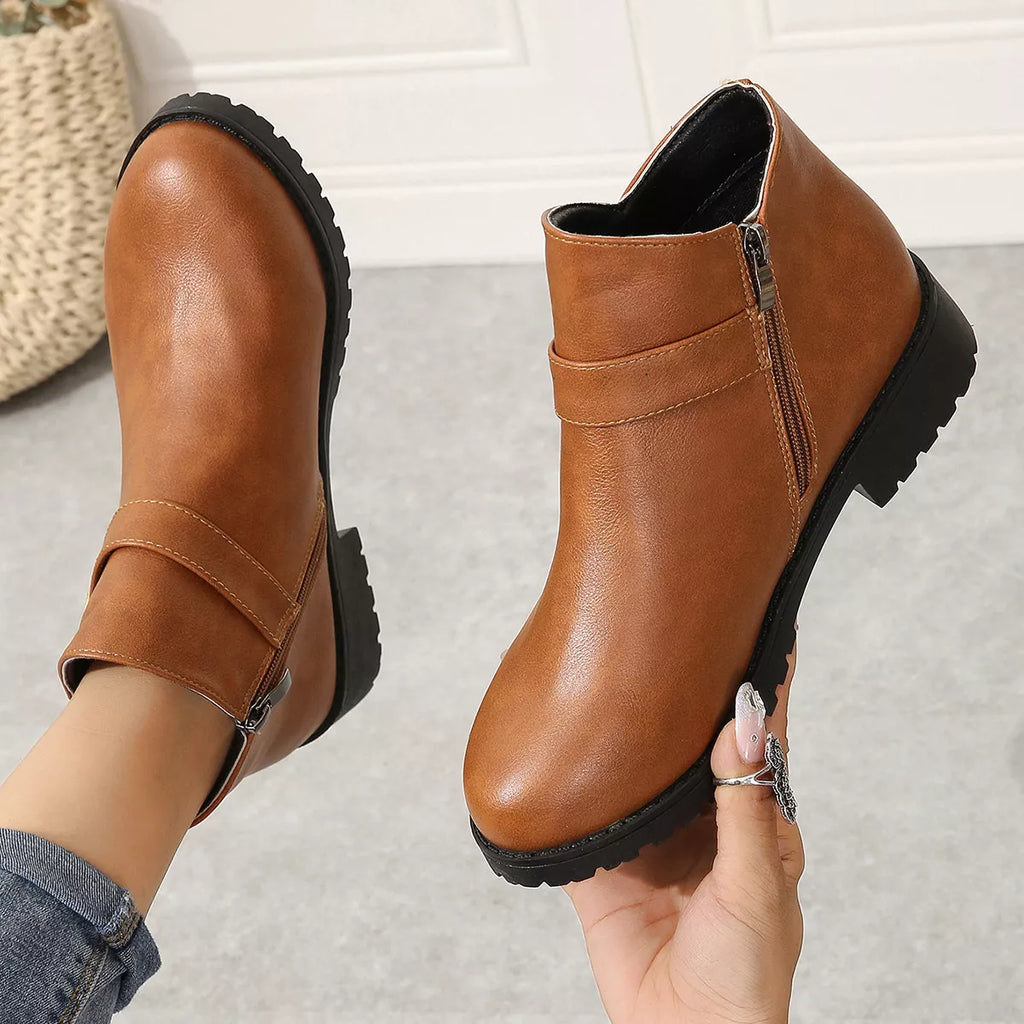 Caramel ankle boots with side zipper, gold buckle strap, chunky sole close-up.