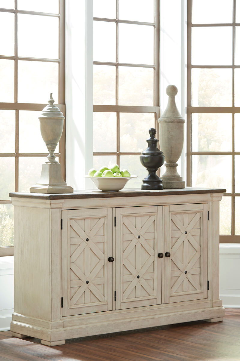 Beige server cabinet with decorative doors and lower storage, set for dining.