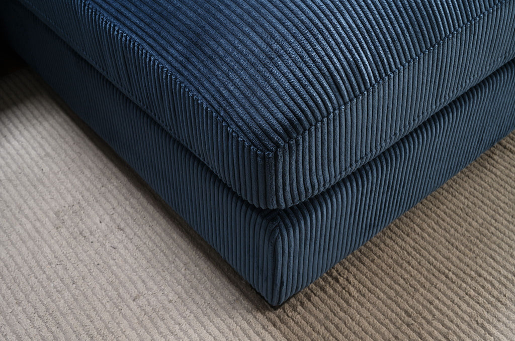 Close-up of dark blue striped upholstery on L-shaped sectional sofa chaise.