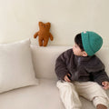 Dark grey kids fleece zip jacket with hood, worn with a green knit beanie.