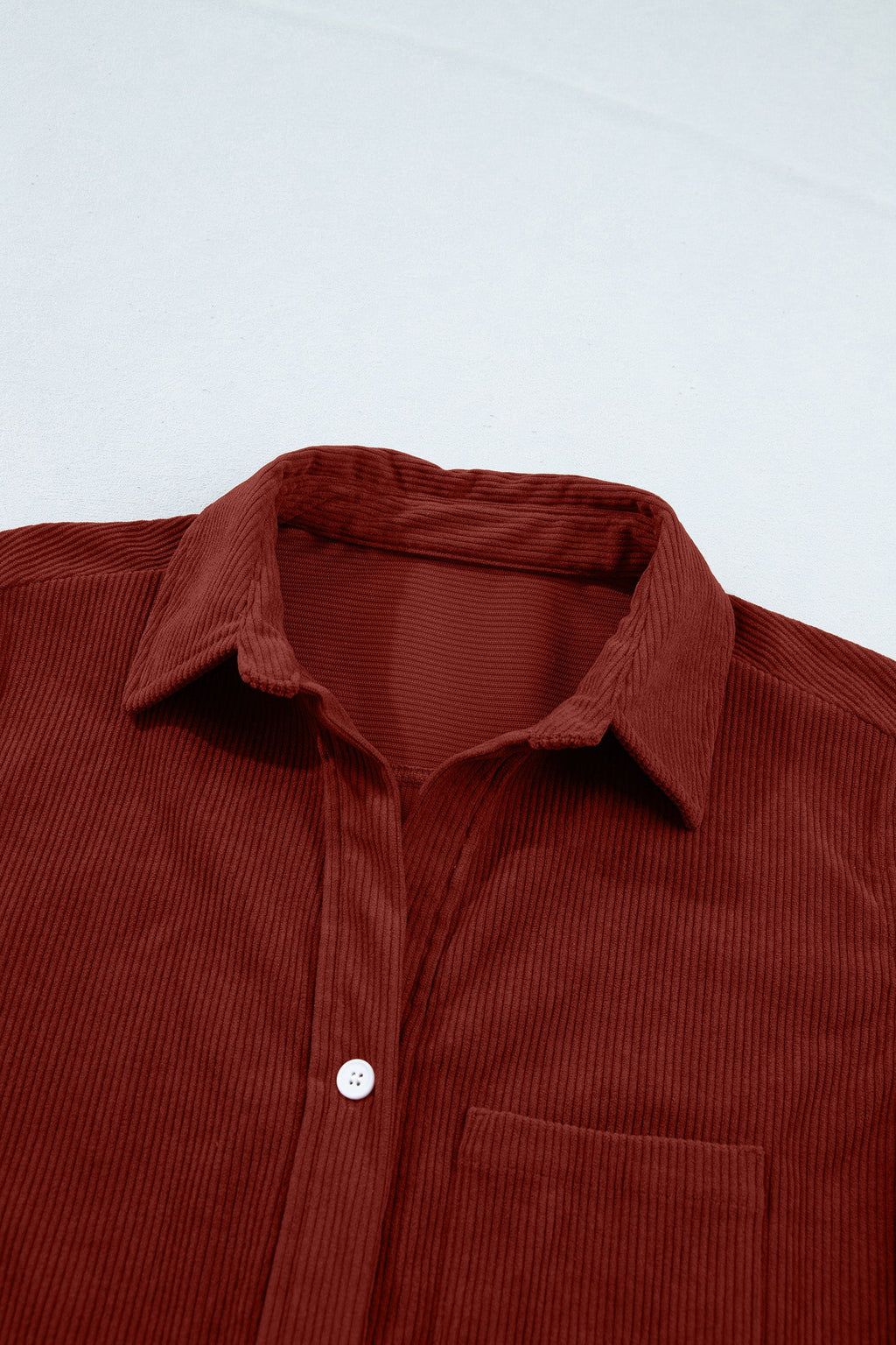Clay corduroy button-up shirt collar close-up with front buttons and chest pocket.