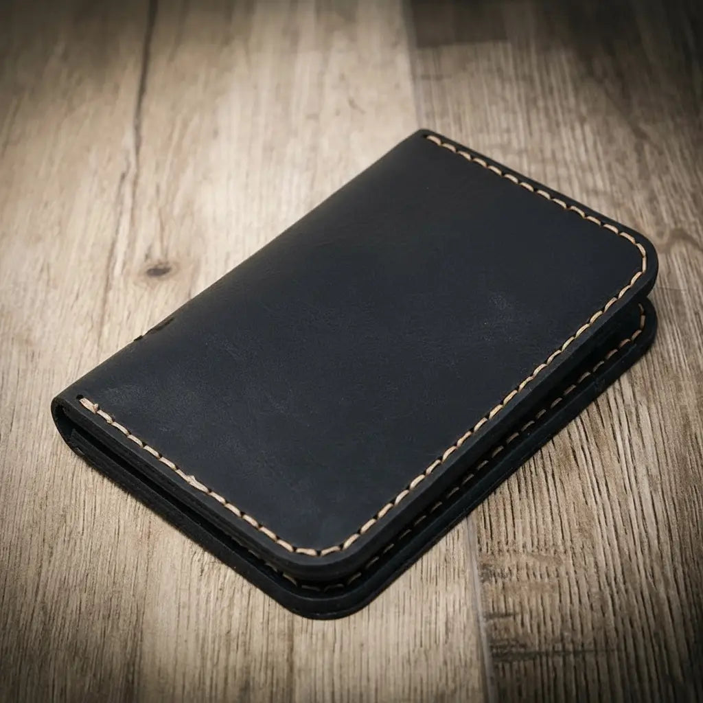 Black vertical leather wallet with contrast tan stitching and fold-over edge