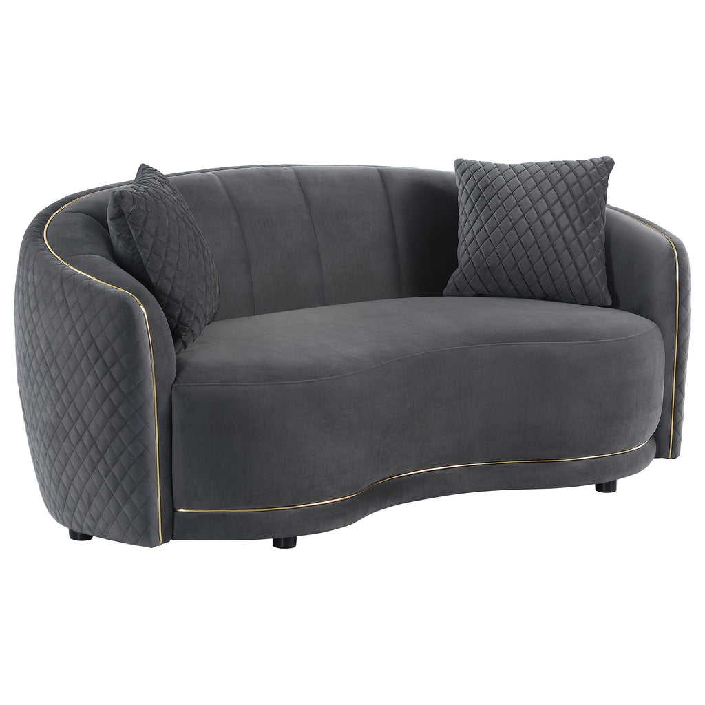 Dark grey velvet loveseat sofa with quilted backrest, two pillows, and gold trim