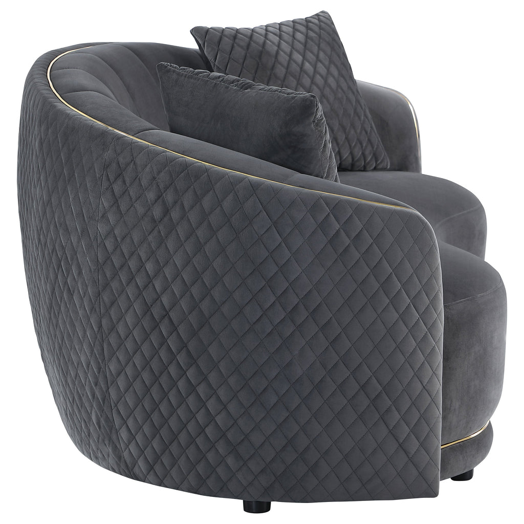 Dark grey velvet lounge sofa with quilted sides, plush seat, and gold edge piping