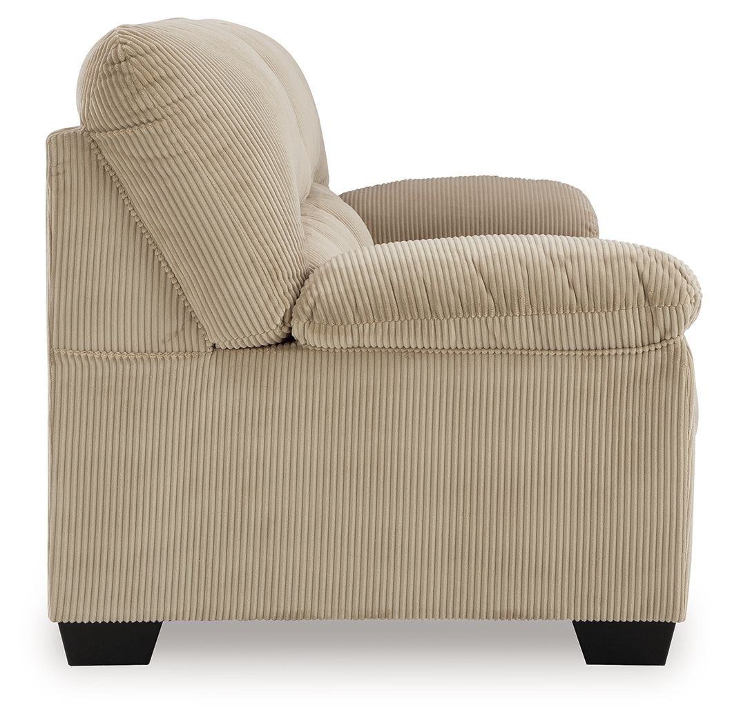 Beige corduroy sofa with rolled arms, tufted back, and block feet