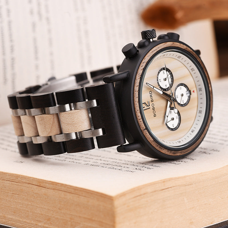 Quartz wristwatch showing black links with beige inlays and a white dial with subdials
