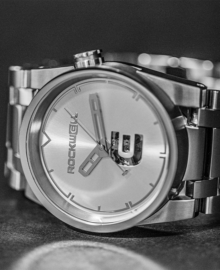 Silver dial close-up with automatic hands, round bezel, metal bracelet links