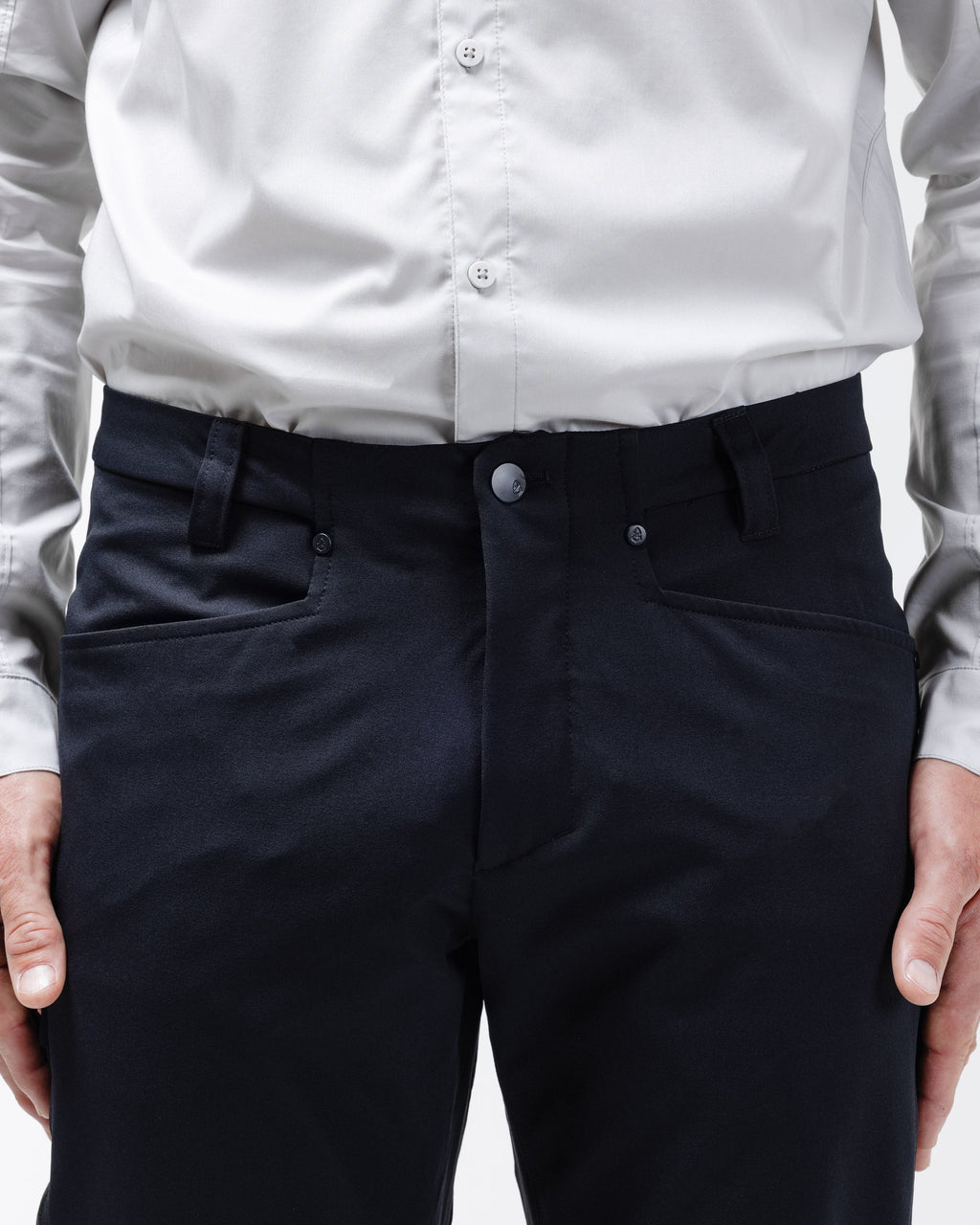 Men's black chino pants front view with button fly and slanted side pockets.