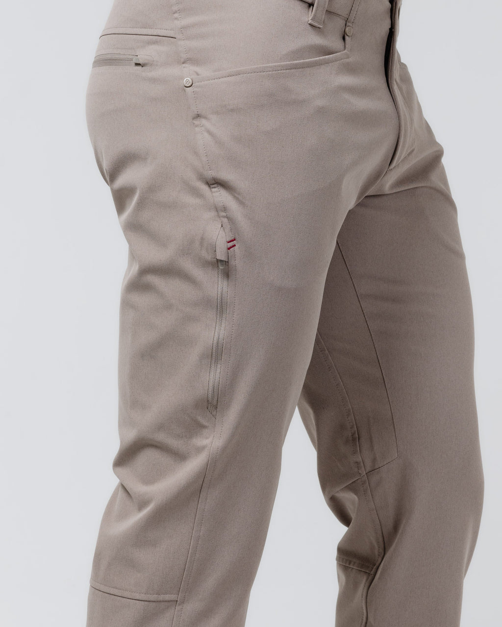 Tan chino pants close-up of front with button closure and side seam