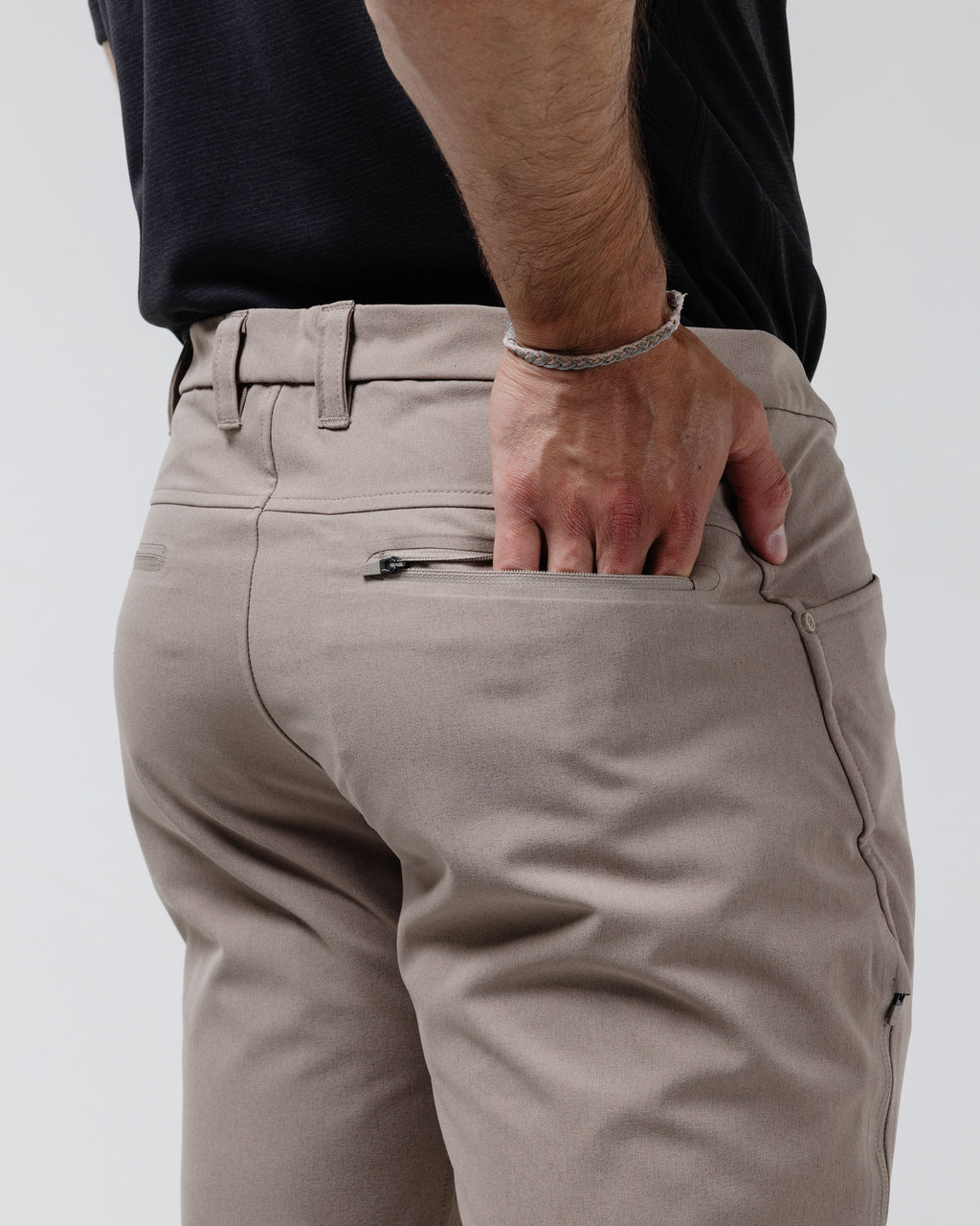 Tan chino pants close-up of front pocket and stitched fly seam