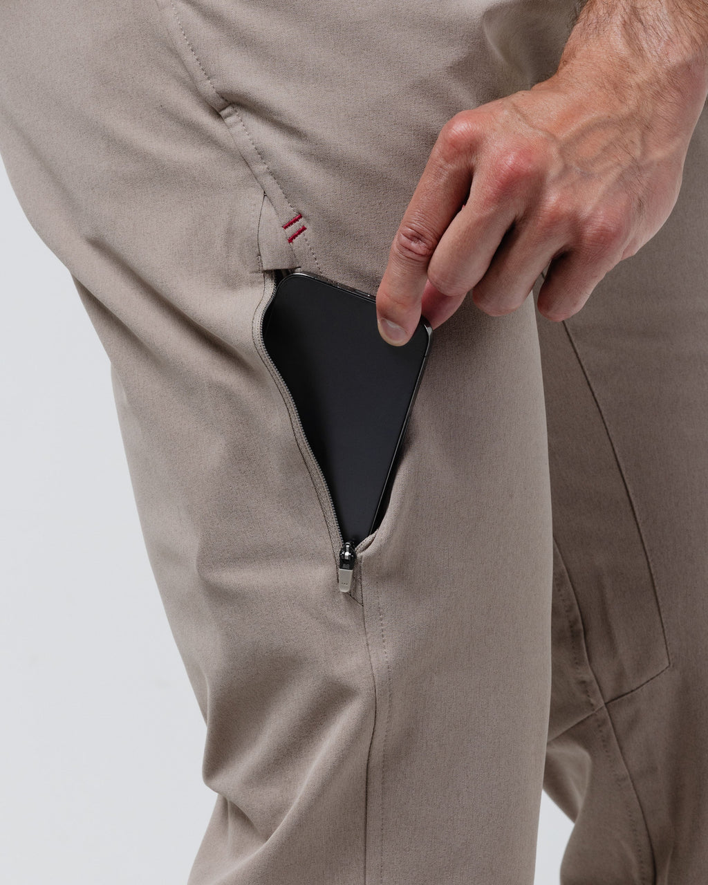 Tan chino pants close-up of zipper coin pocket opening at side