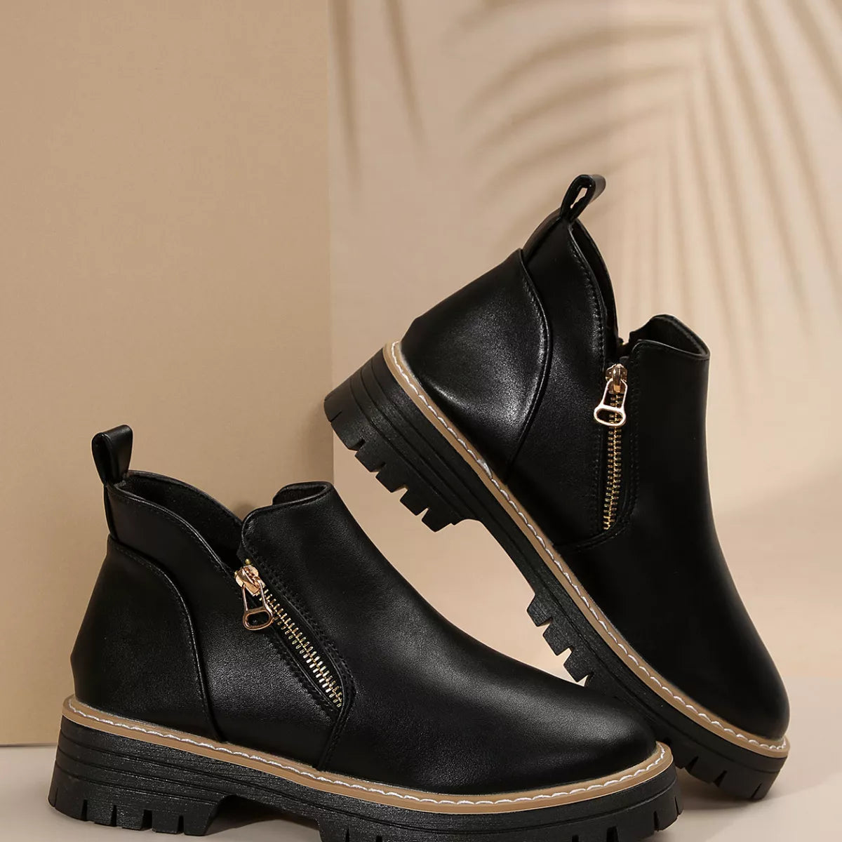 Pair of black ankle boots with side zipper and chunky lug outsole