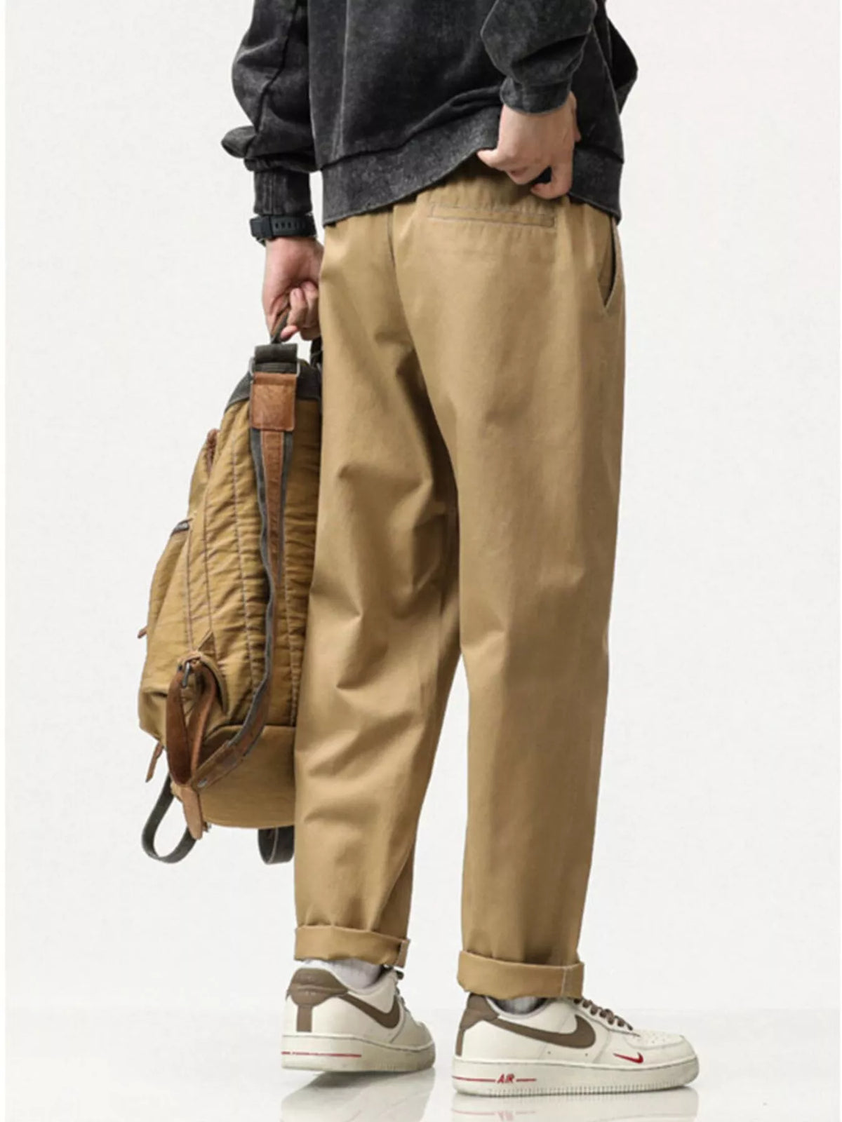 Khaki loose-fit pants with cuffed hems and side pockets, styled with sneakers