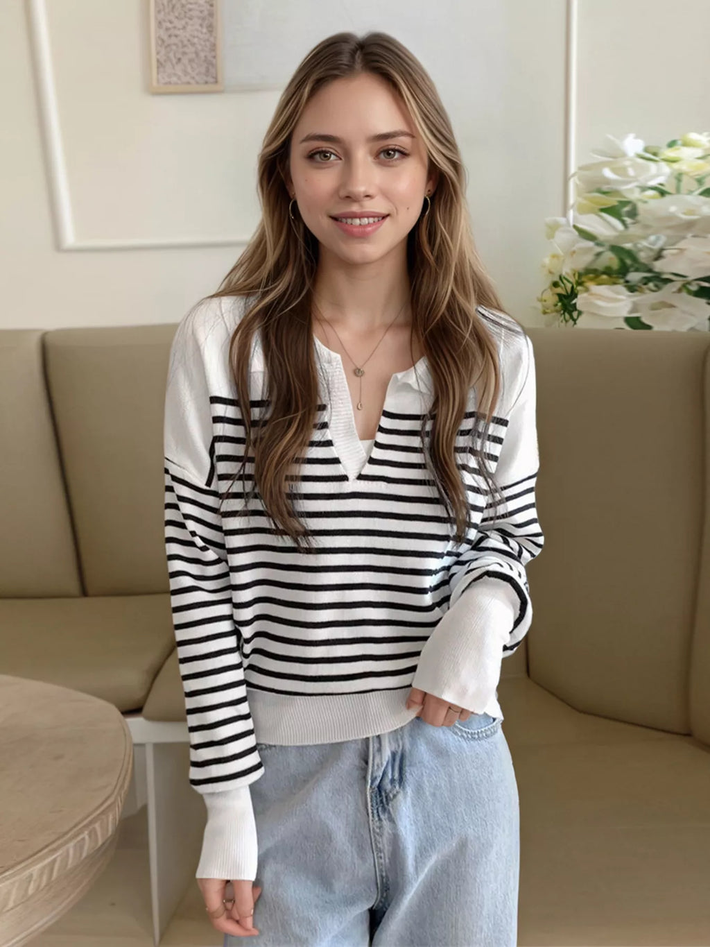 Black-and-white striped knit long-sleeve top with buttoned V-neck placket, relaxed fit