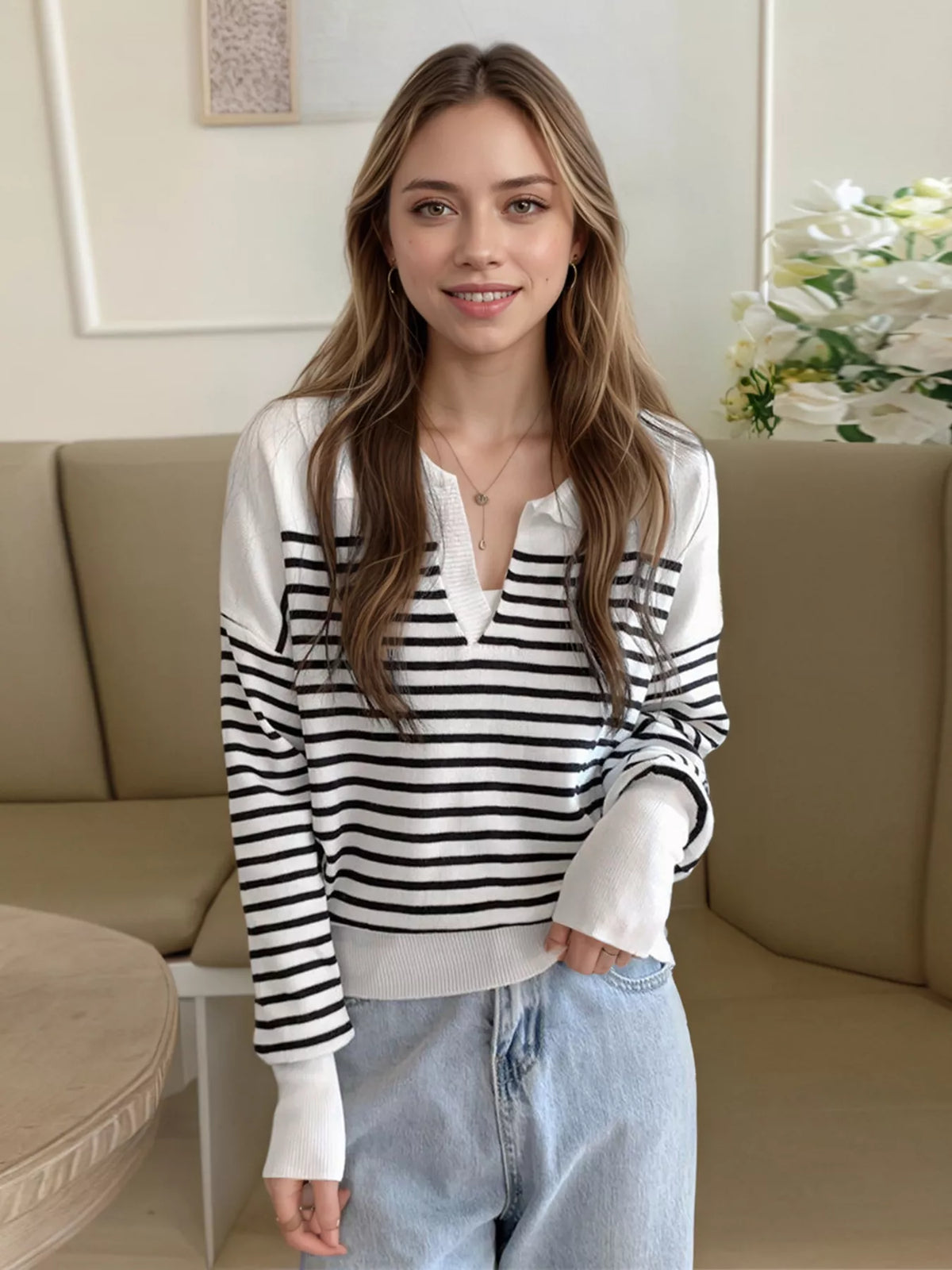 Black-and-white striped knit long-sleeve top with buttoned V-neck placket, relaxed fit