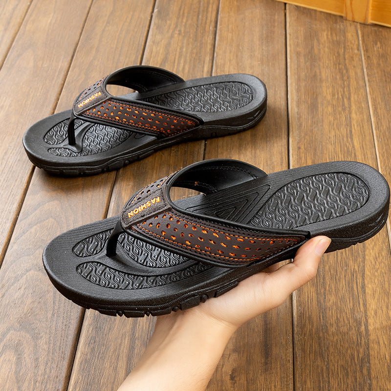Black men’s flip-flop sandals with orange perforated strap, side angle, textured rubber sole