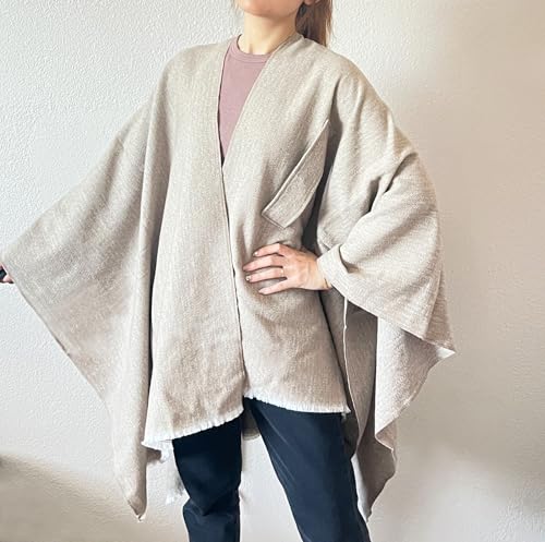 Beige women's open-front fringe poncho shawl with tie belt, layered over top