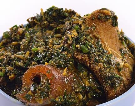 Bowl of seasoned vegetable soup with greens and chunks