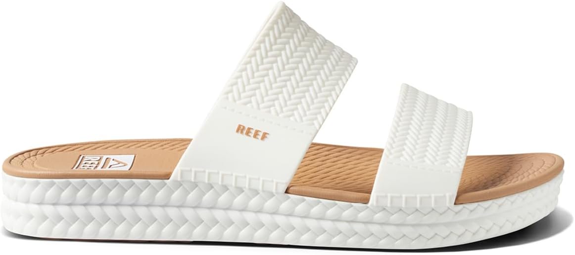 White platform slide sandals with tan footbed and REEF-branded straps