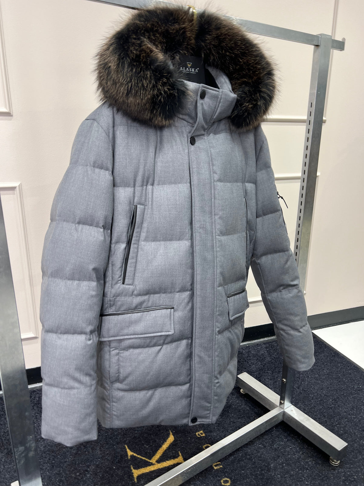 Men's grey puffer coat with fur-trimmed hood, button front, and patch pockets