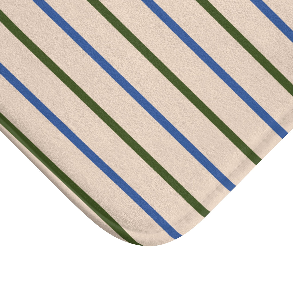 Close-up of striped bath mat corner with blue and green lines on beige fabric