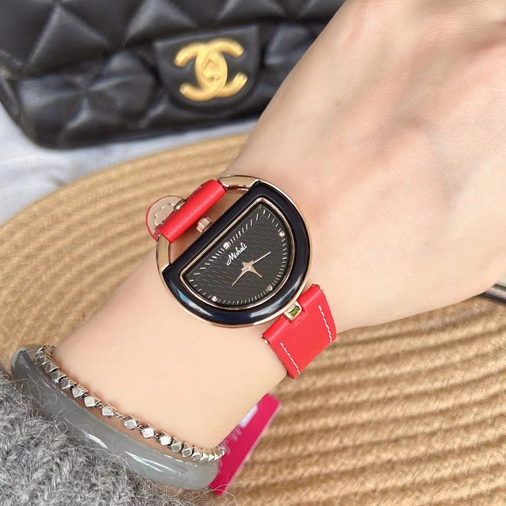 Women’s leather-strap watch with red band and gold-toned oval case, dark dial.