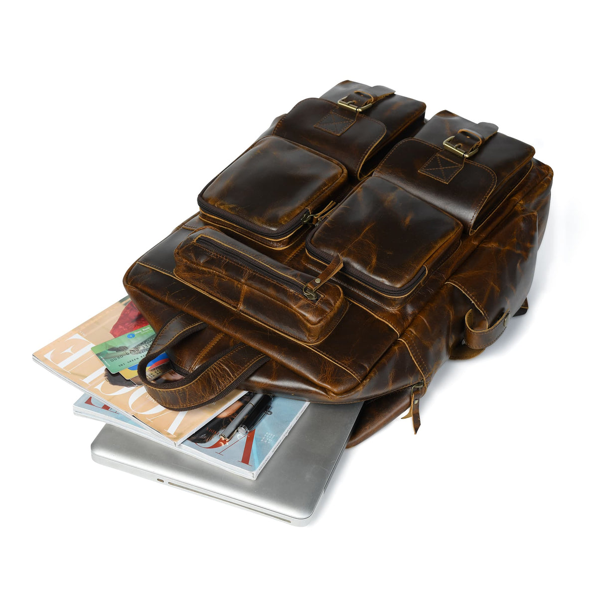 Brown leather backpack showing front pockets and buckled straps over documents