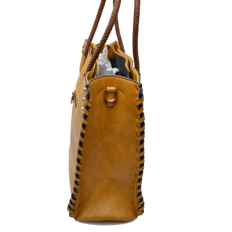 Mustard faux leather tote side view with braided handles and gold studded trim around seams