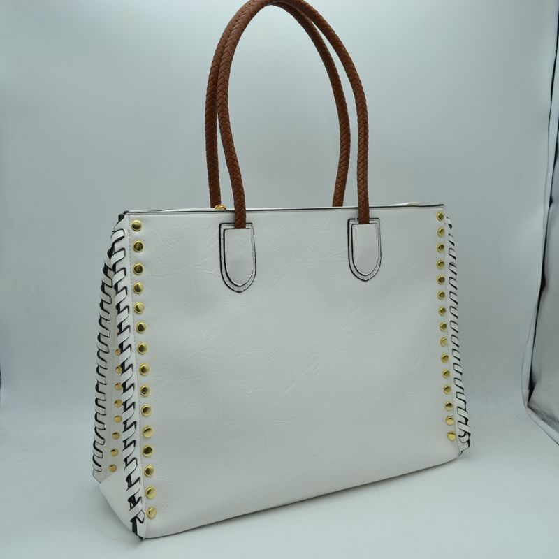 White faux leather tote bag with studded sides, whipstitch trim, and dual rope handles