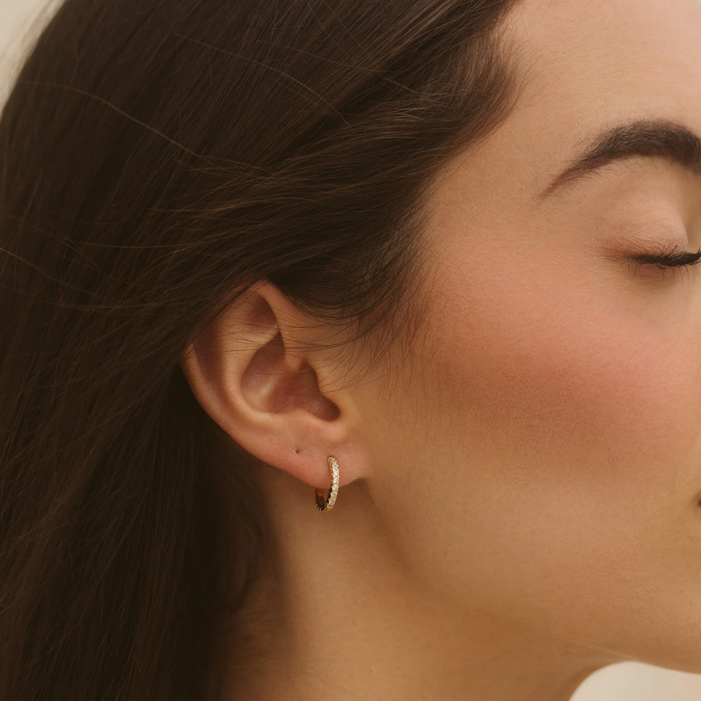 Gold hoop earring on ear