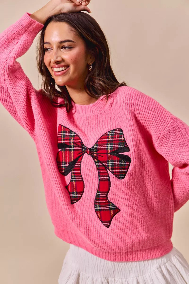 Pink knit sweater with large plaid bow ribbon detail at the center front