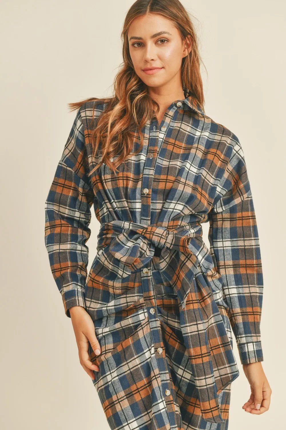 Plaid flannel shirt dress close-up: button placket and tied waist belt