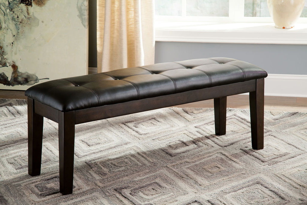 Dark brown upholstered dining bench with tufted black cushion and square legs