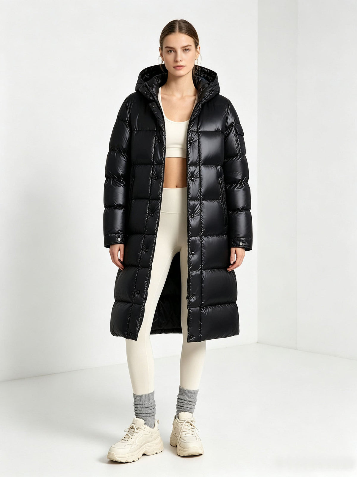 Black long padded hooded coat with front zipper and quilted puffer panels, over-the-knee