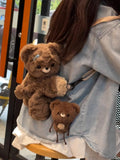 Brown plush teddy bear backpack bag with a small bear charm attached at the front