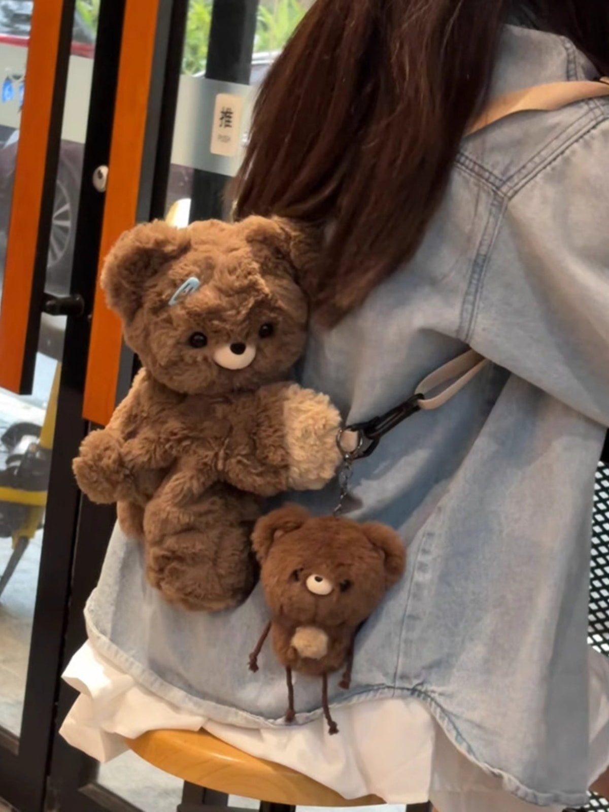 Brown plush teddy bear backpack bag with a small bear charm attached at the front