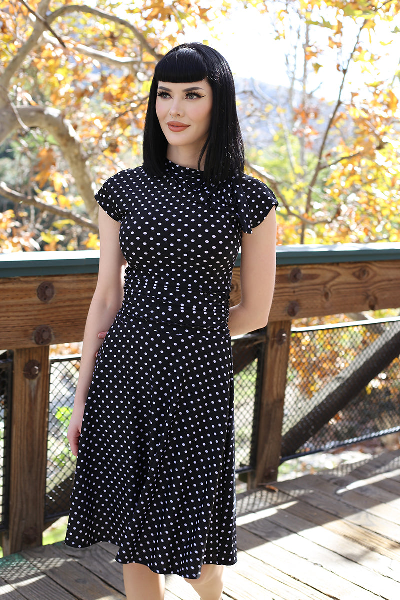 Black polka-dot bombshell dress with short sleeves and high neckline