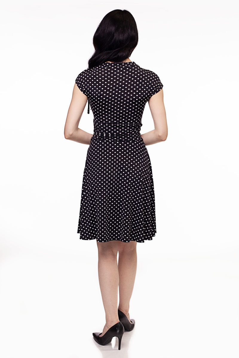 Back view of black polka-dot midi dress with short sleeves and gathered waist
