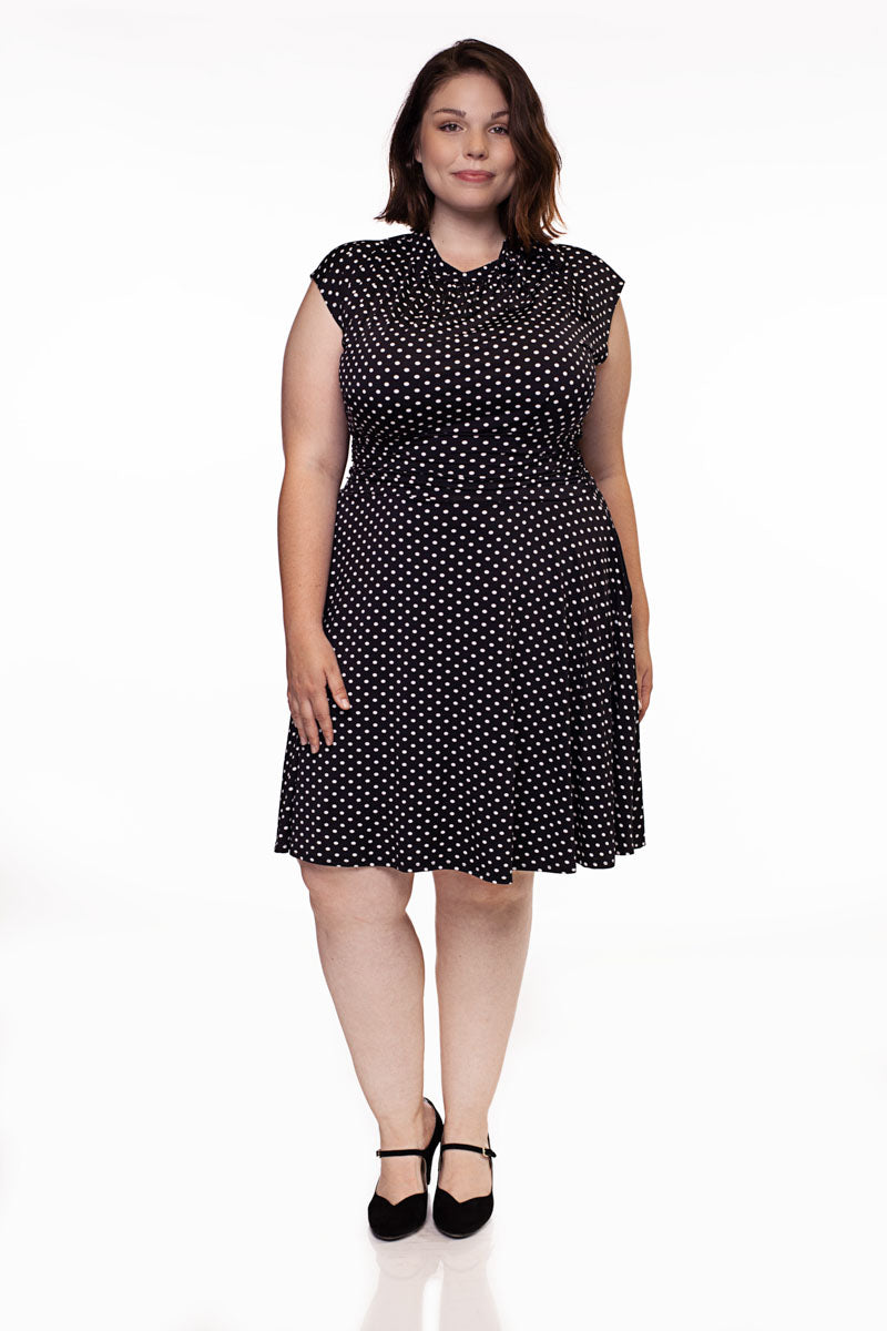 Black polka-dot midi dress with short cap sleeves, gathered waist, and high neckline