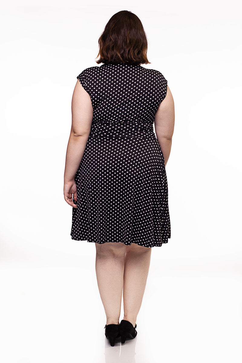 Back view of black polka-dot fit-and-flare dress with short cap sleeves