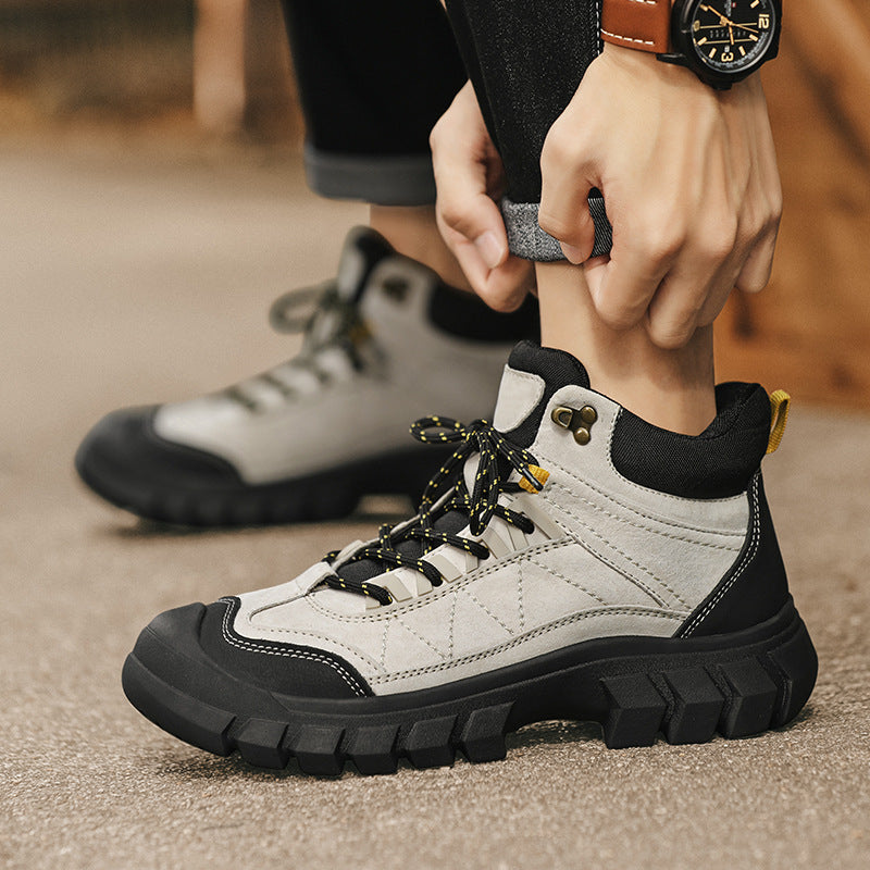 White and black lace-up high-top hiking boot on ground with rugged tread sole