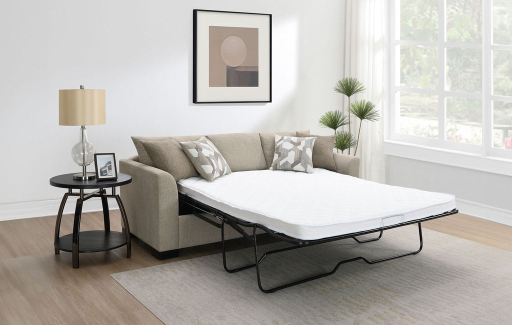 Camel upholstered sleeper sectional chaise sofa with extended white mattress and dark platform legs.