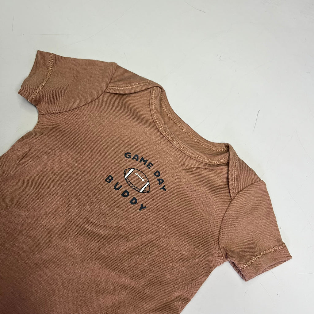 Brown short-sleeve bodysuit with “Game Day Buddy” logo on the chest.