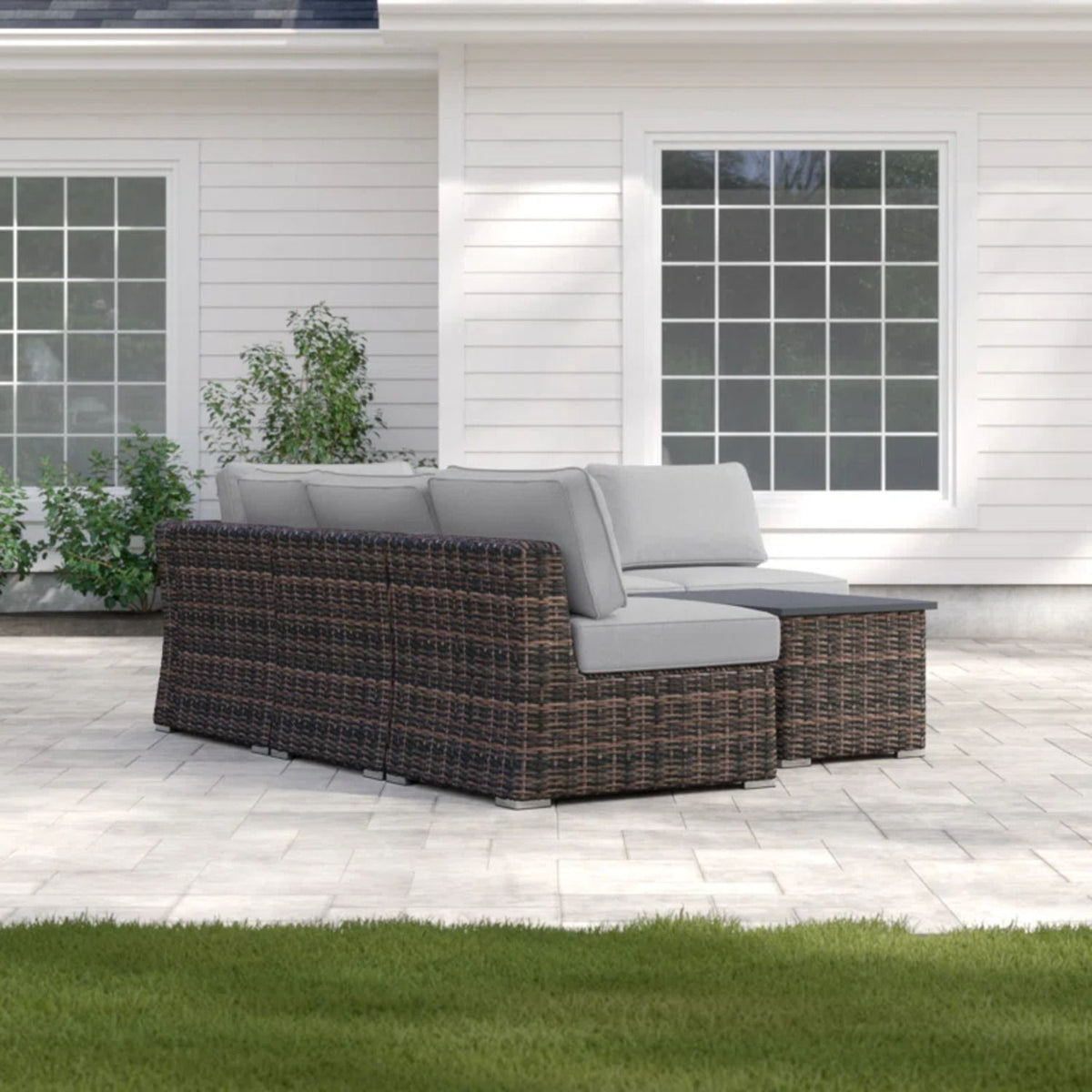 Dark wicker sectional sofa with gray cushions and integrated corner table