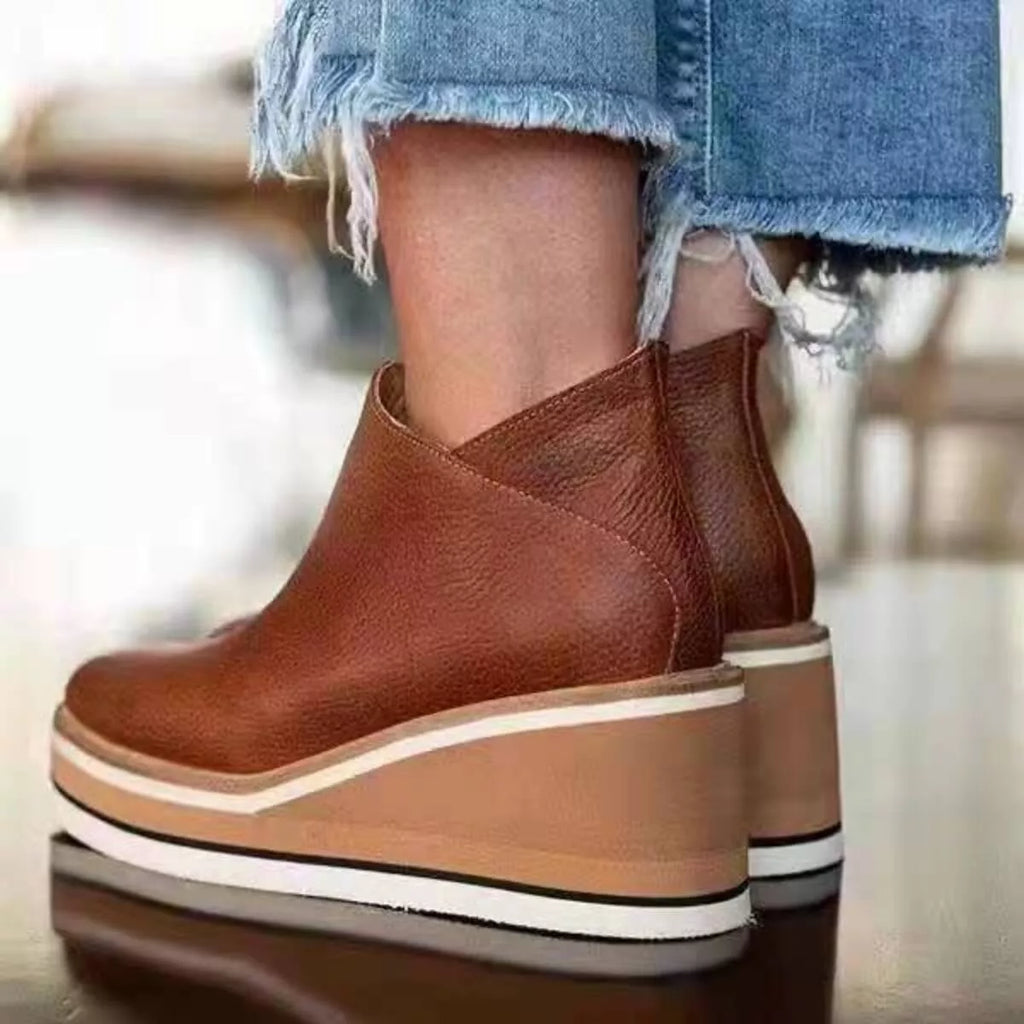 Rust-brown ankle wedge boots with side zipper and striped sole