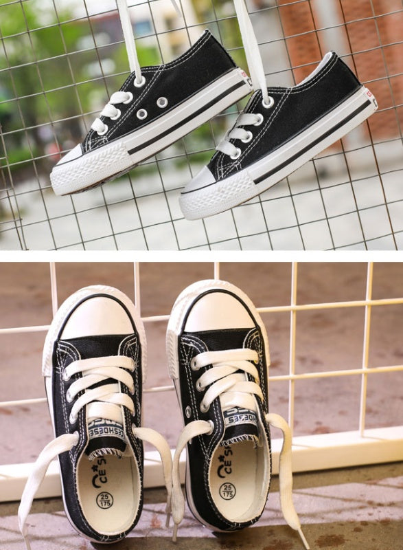 Black low-top canvas sneakers with white laces and rubber sole