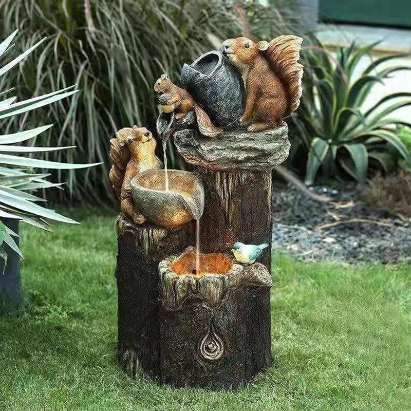 Resin squirrel garden fountain with orange-lit water in lower basin