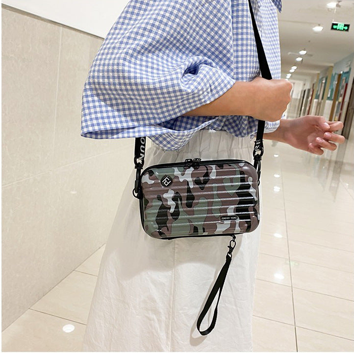 Cosmetic bag with dark camo print, black zipper, and shoulder strap