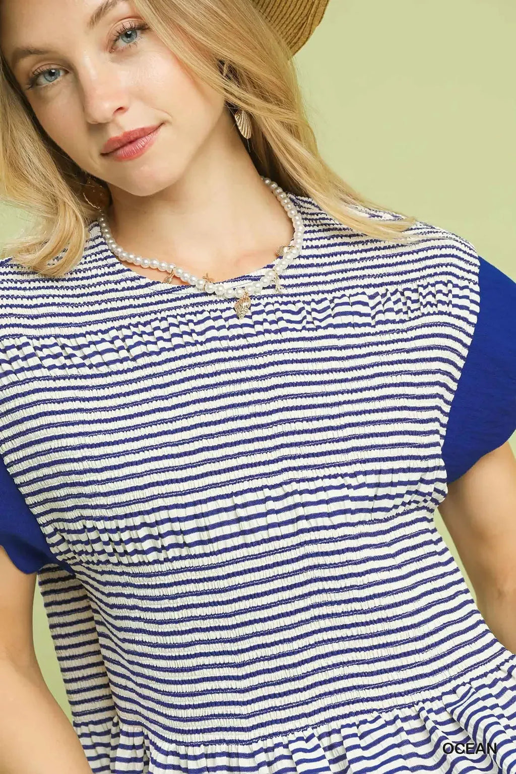 Close-up of navy-and-white striped peplum top neckline and ruffle sleeve